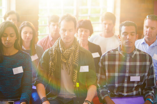 Serene people with eyes closed in audience - Powered by Adobe