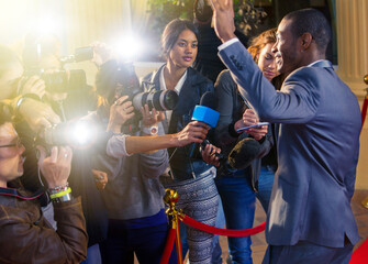 Celebrity waving at paparazzi photographers at red carpet event
