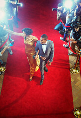 Celebrity couple arriving at event waving and walking the red carpet