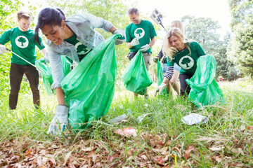 Environmentalist volunteers picking up trash in field