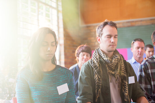 Serene people with eyes closed in audience