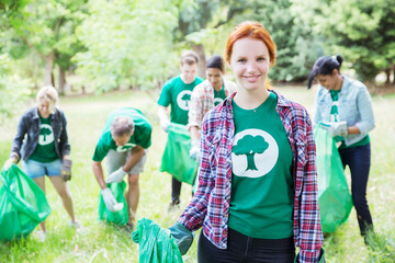 Portrait of smiling environmentalist volunteer picking up trash