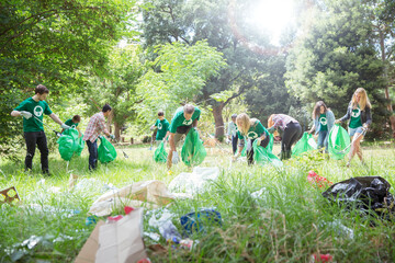 Environmentalist volunteers picking up trash in field