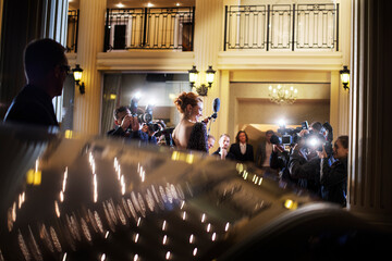 Celebrity arriving at event and being photographed by paparazzi