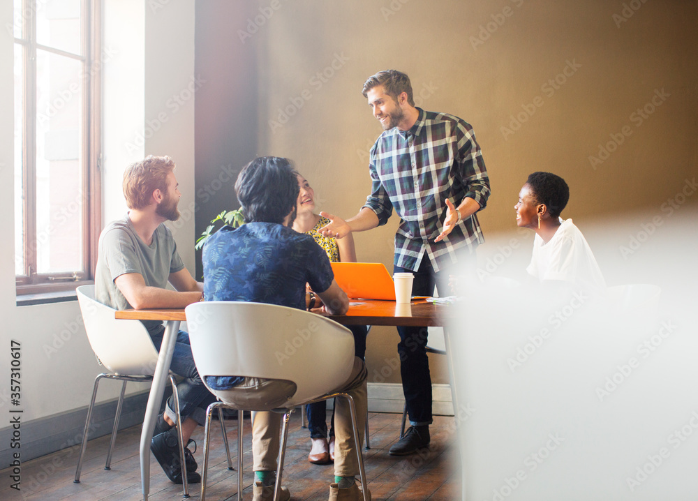 Wall mural casual businessman leading meeting at table in office