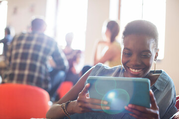 Smiling casual businesswoman using digital tablet in office