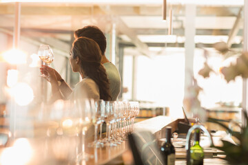Couple wine tasting in sunny winery tasting room
