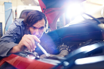 Mechanic working on engine in auto repair shop