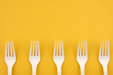 The concept of eco fast food. Forks of eco-friendly material on a yellow background close-up with a copy space