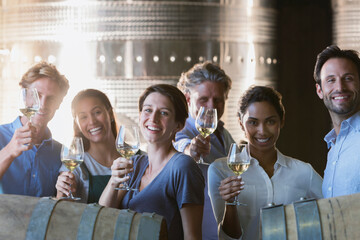 Portrait smiling friends wine tasting in winery cellar