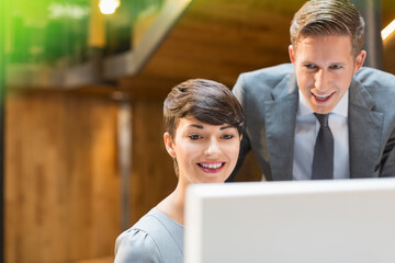 Businessman and businesswoman using computer in office