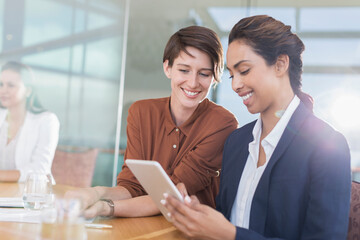 Smiling businesswomen using digital tablet in office