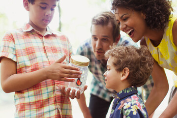 Family watching butterfly in jar