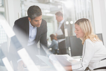 Business people reviewing paperwork in conference room
