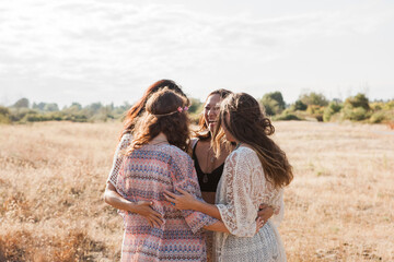 Boho women hugging in rural field © Monashee Alonso/KOTO