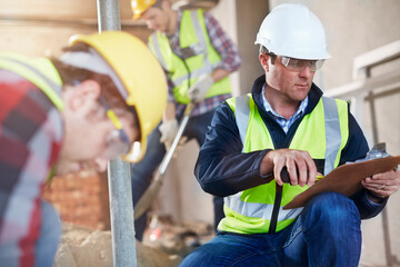 Foreman with clipboard at construction site