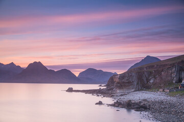 Fototapeta na wymiar Pink sunset sky over mountains and calm lake, Elgol, Skye, Scotland