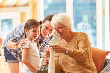 Grandmother teaching granddaughter knitting