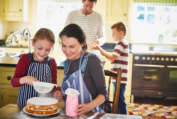 Family baking cake in kitchen