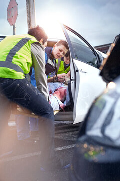 Rescue workers removing car accident victim from car