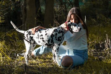 Chica de melo moreno juega con su dálmata