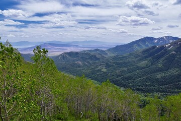 Rocky Mountain Wasatch Front peaks, panorama landscape view from Butterfield Canyon Oquirrh range toward Provo, Tooele Utah Lake by Rio Tinto Bingham Copper Mine, Great Salt Lake Valley in spring. Uta