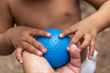 Father and son play, Child hands with ball and adult hand