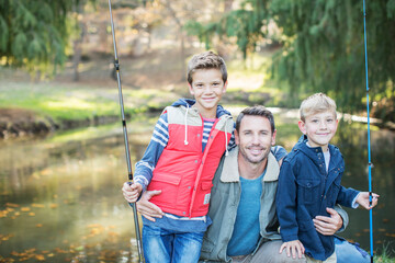 Portrait smiling father and sons with fishing rods