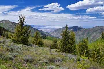 Obraz premium Rocky Mountain Wasatch Front peaks, panorama landscape view from Butterfield Canyon Oquirrh range toward Provo, Tooele Utah Lake by Rio Tinto Bingham Copper Mine, Great Salt Lake Valley in spring. Uta