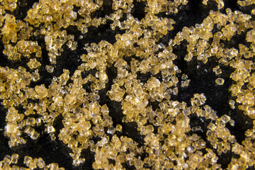 Chrystals sugar, brown cane sugar isolated on black background.