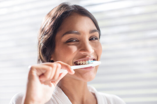 Close up portrait smiling woman brushing teeth
