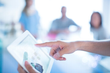 Close up businessman pointing to digital tablet in meeting
