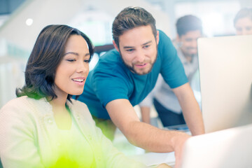 Creative business people using laptop in office