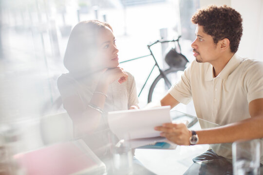 Creative Business People Reviewing Paperwork In Office