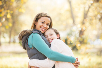 Fototapeta premium Portrait of smiling mother and daughter hugging outdoors
