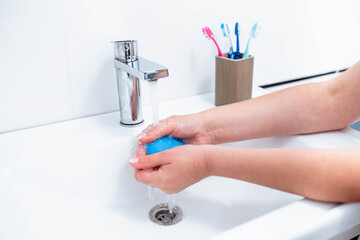 Hand washing with human soap and water to prevent coronavirus viruses, hygiene to stop the spread of coronavirus. Woman uses soap and washes her hands under the tap. Hand hygiene concept detail.