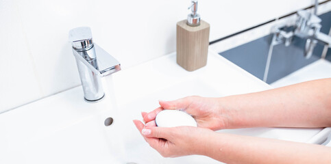 Hand washing with human soap and water to prevent coronavirus viruses, hygiene to stop the spread of coronavirus. Woman uses soap and washes her hands under the tap. Hand hygiene concept detail.