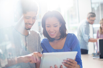 Business people using digital tablet in sunny office