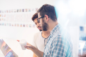 Creative graphic designers with coffee discussing proofs