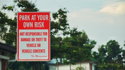Park at your own risk sign board at housing area.
Sign board for indicating of not responsible for damage or theft to vehicle or vehicle contents