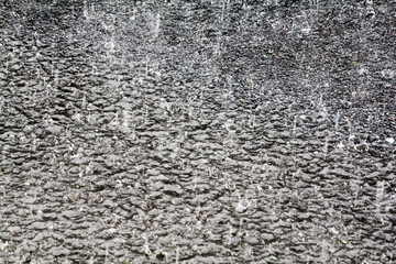 Heavy rain drops on asphalt.