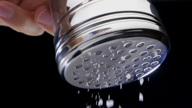 Salt flies straight into the camera on black background. Slow motion.