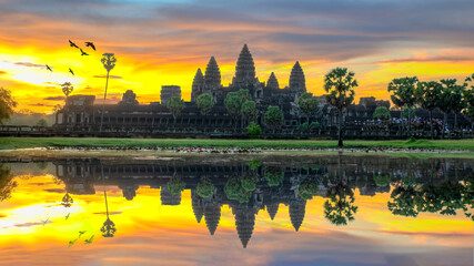 Fototapeta na wymiar Sunrise view of popular tourist attraction ancient temple complex Angkor Wat with reflected in lake Siem Reap, Cambodia.