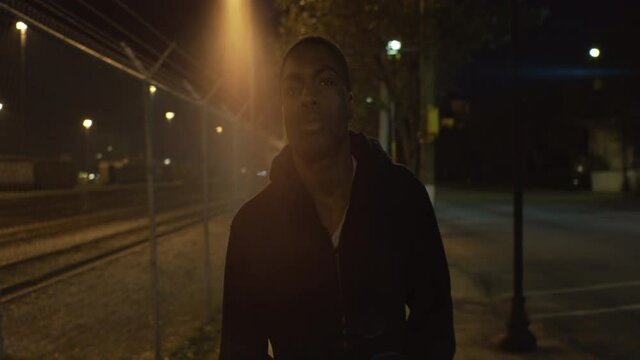 African American Teen Walks Down Street at Night, Front Medium