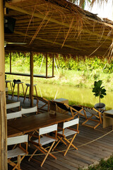 Wood seats under roof for relax beside a pond