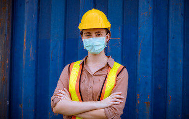 Portrait woman dock worker under working and checking production process on dock container warehouse and safety mask face to protect for pollution and virus in factory.