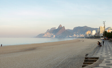 Panorama of early morning Ipanema beach in Rio de Janeiro reopened after a long time quarantine with a few people already exercising [June 12, 2020]