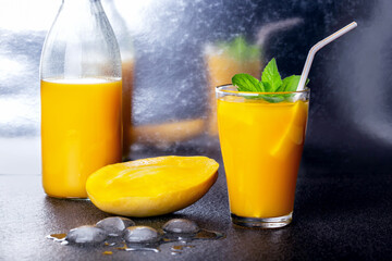 Fresh juice of a mango smoothies in a glass  and ripe mango fruit.