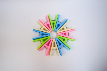 Circle-shaped colorful clothespins on a white background