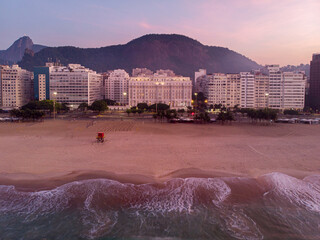 Copacabana beach at sunrise with the ocean waves coming in showing the colourful skies over the Rio...
